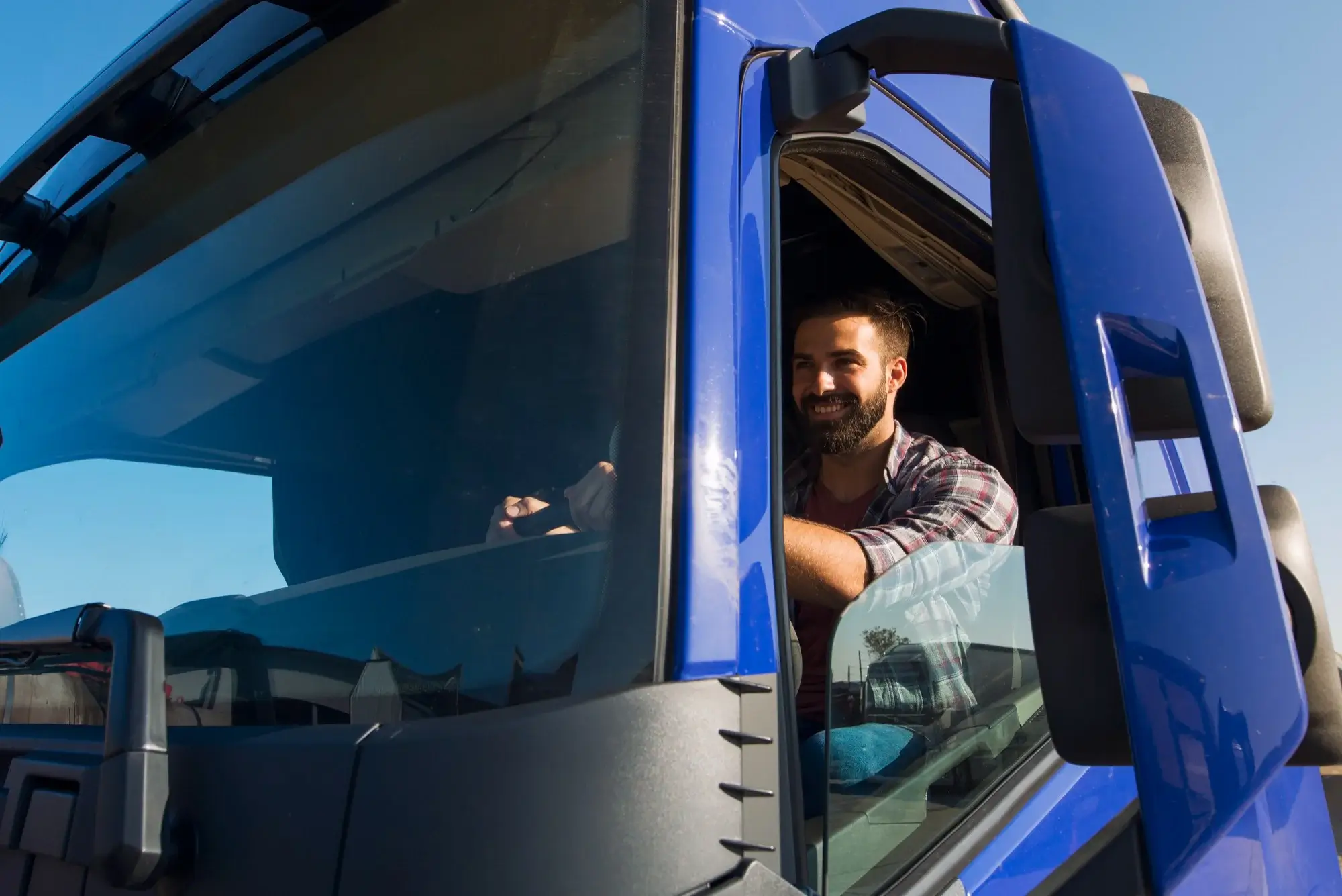 Driver smiling happily driving his truck transporting heavy loads